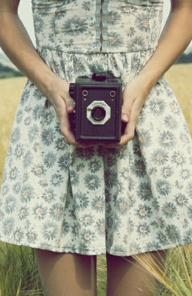 Девушка со старинным фотоаппаратом в летнем легком платье